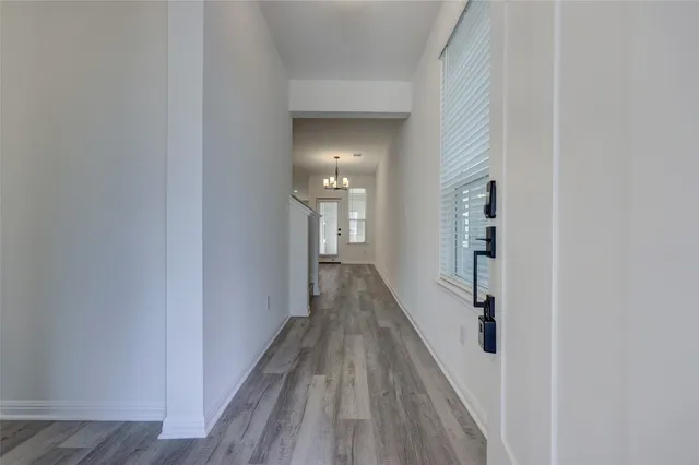 a view of a hallway with wooden floor and closet