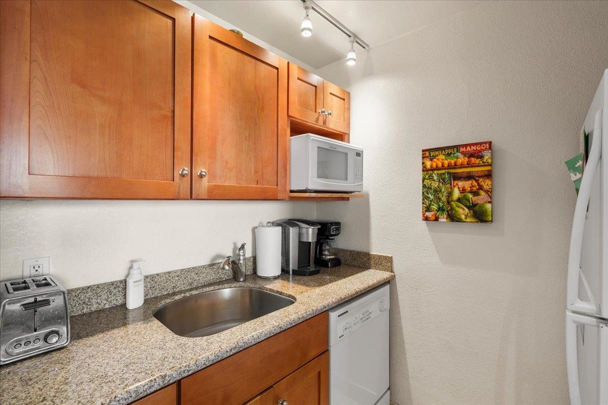 2191 South Kihei Road, Unit 2419 Kihei, HI 96753 - Photo 16 of 27 a kitchen with stainless steel appliances granite countertop a sink a refrigerator and cabinets