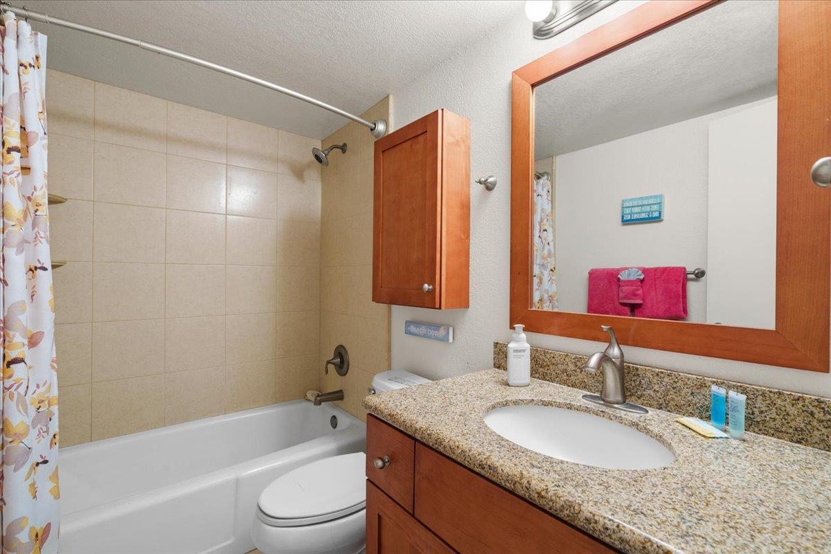 2191 South Kihei Road, Unit 2419 Kihei, HI 96753 - Photo 22 of 27 a bathroom with a granite countertop sink toilet mirror and shower