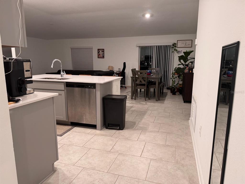 Undisclosed Address Leesburg, FL 34748 - Photo 4 of 11 a kitchen with stainless steel appliances a sink a counter top space cabinets and a view of living room