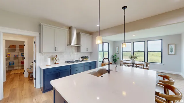 a large kitchen with stainless steel appliances a large center island attached withe living room