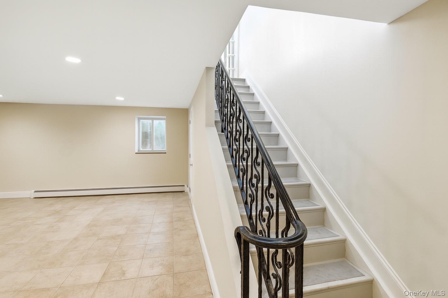 1-76 Beach 101st Street, Unit 4A Queens, NY 11694 - Photo 9 of 16 Stairway featuring a baseboard heating unit, recessed lighting, and tile patterned floors