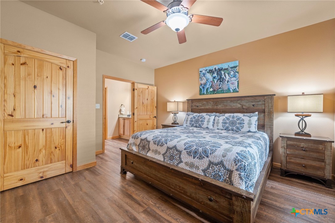 1554 Gruene Road, Unit A10 New Braunfels, TX 78130 - Photo 17 of 32 a bedroom with a bed and a chandelier