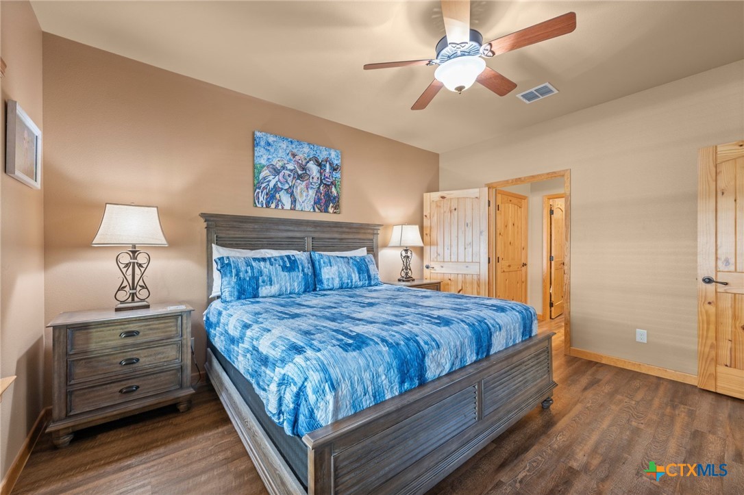 1554 Gruene Road, Unit A10 New Braunfels, TX 78130 - Photo 22 of 32 a bedroom with a bed and a chandelier