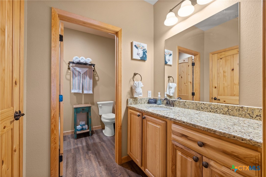 1554 Gruene Road, Unit A10 New Braunfels, TX 78130 - Photo 23 of 32 a en suite bathroom with a granite countertop sink and a mirror