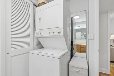 a view of washer and dryer with bathroom in the background