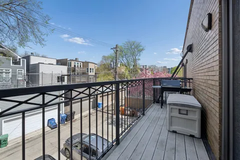 a view of a balcony with chairs and wooden floor