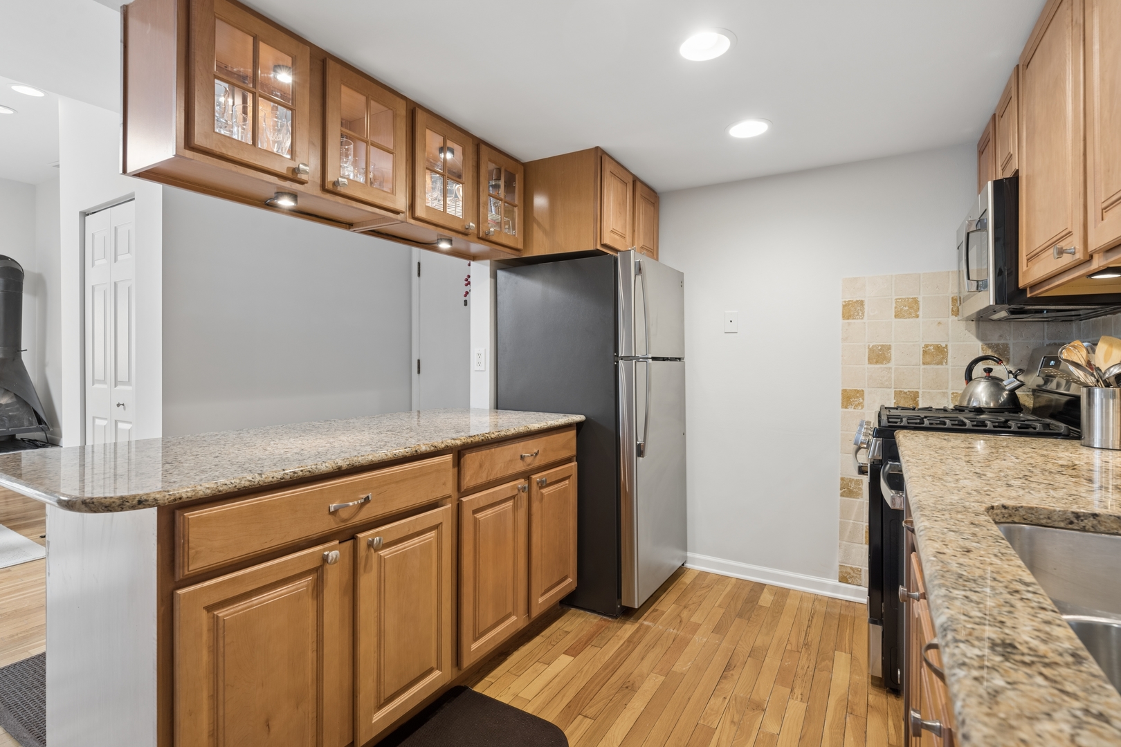 1122 West Altgeld Street, Unit 12 Chicago, IL 60614 - Photo 10 of 20 a kitchen with stainless steel appliances granite countertop a refrigerator a stove and a sink with cabinets