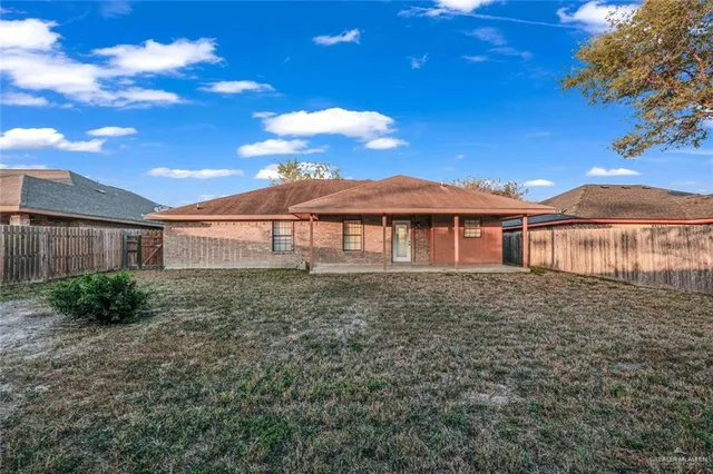 a view of a yard in front of a house with a large tree