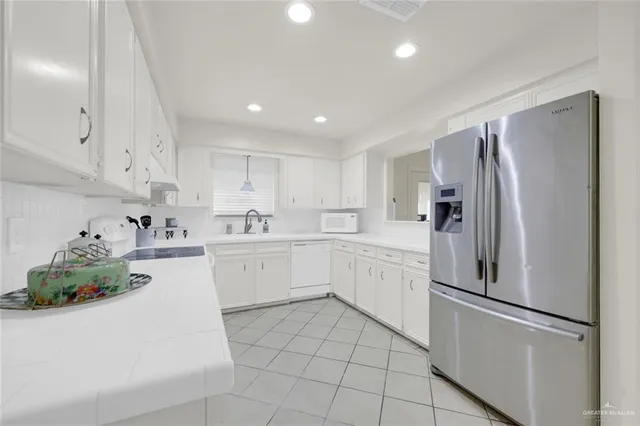 a kitchen with white cabinets and white appliances