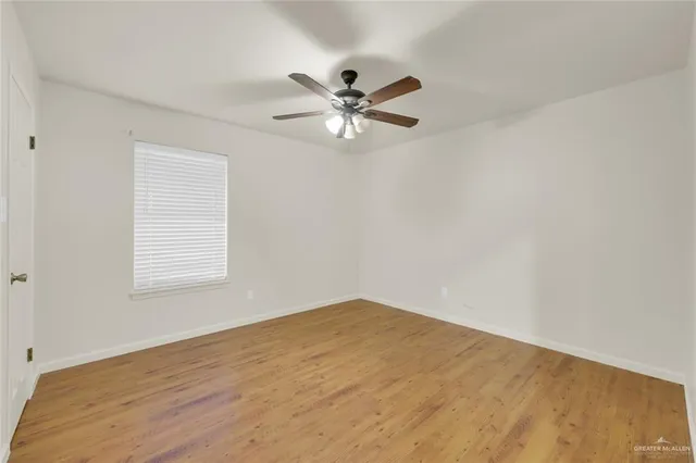 an empty room with a window and a fan