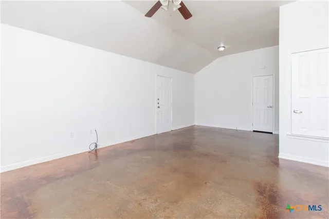 an empty room with ceiling fan and window