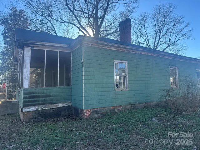 a view of brick house with a small yard
