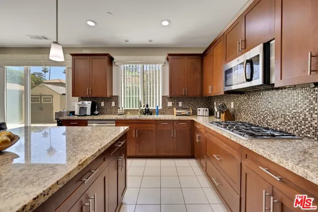 a kitchen with stainless steel appliances granite countertop a sink stove and cabinets
