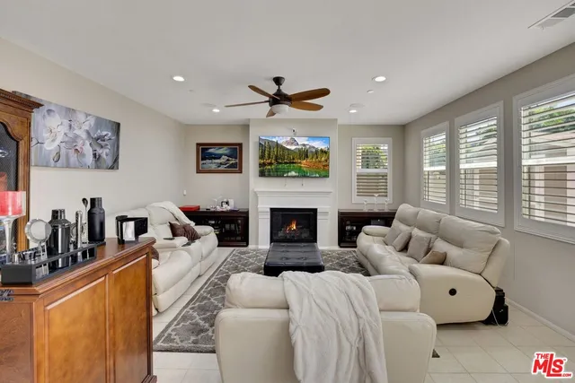 a living room with furniture a large window and a fireplace