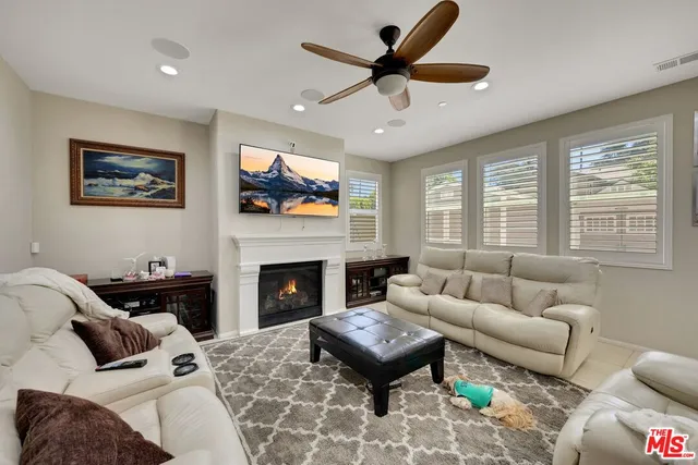 a living room with furniture a flat screen tv and a fireplace