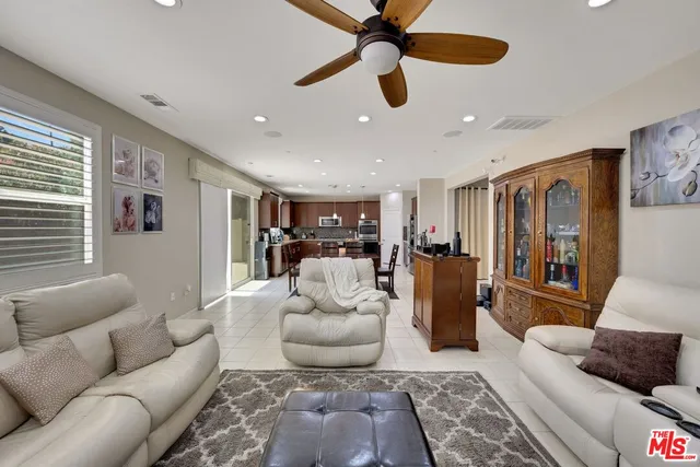 a living room with furniture and a ceiling fan