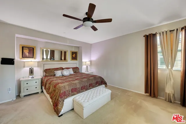 a bedroom with a large bed and a chandelier