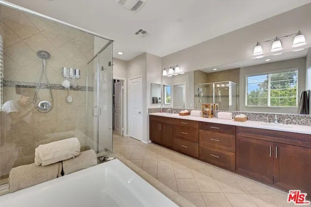 a large bathroom with a double vanity sink mirror and bathtub