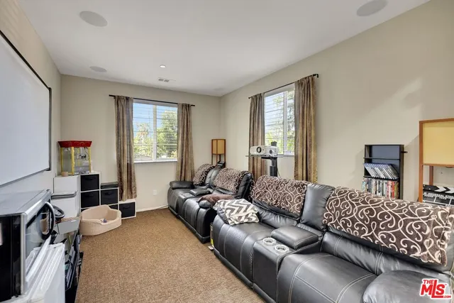 a living room with furniture a flat screen tv and a window