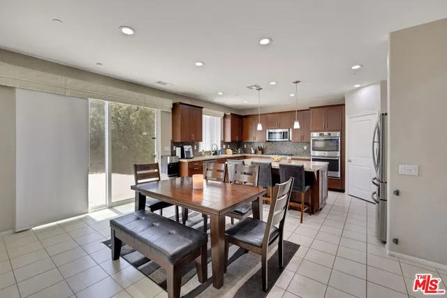 a dining room with kitchen island furniture a large window and kitchen view
