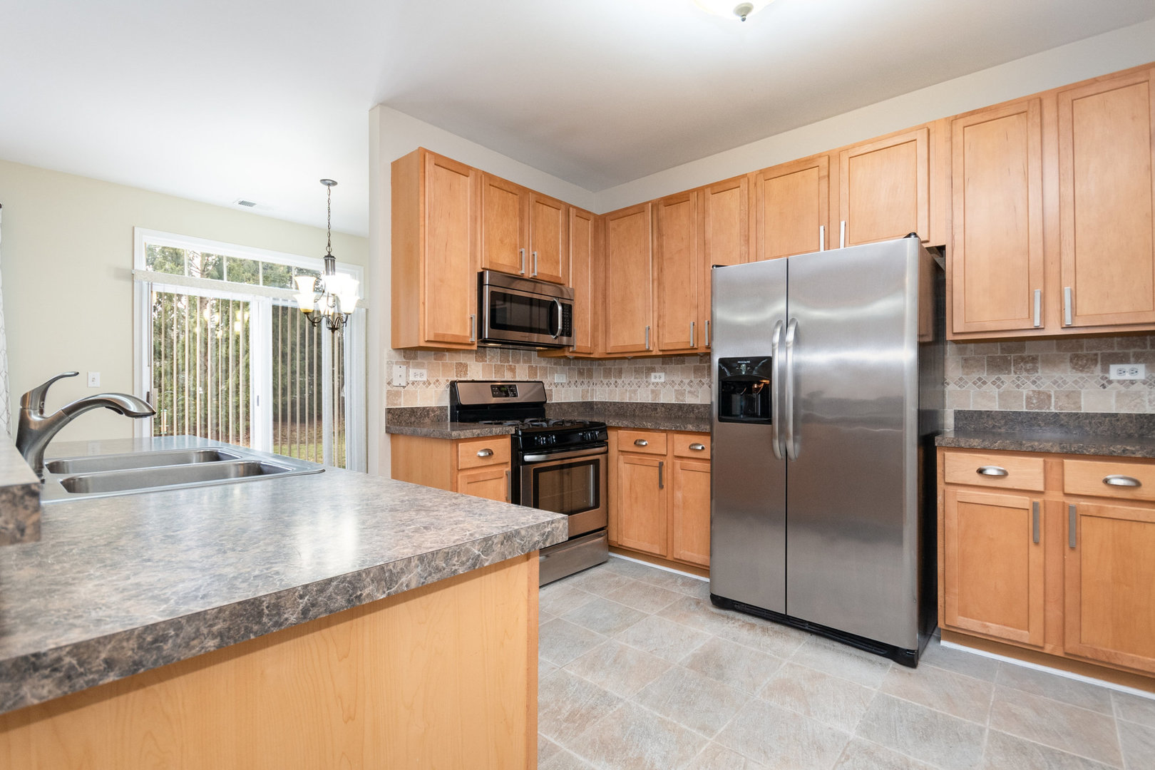 608 Springbrook Trail North Oswego, IL 60543 - Photo 8 of 24 a kitchen with stainless steel appliances granite countertop a refrigerator a sink a stove a microwave and island