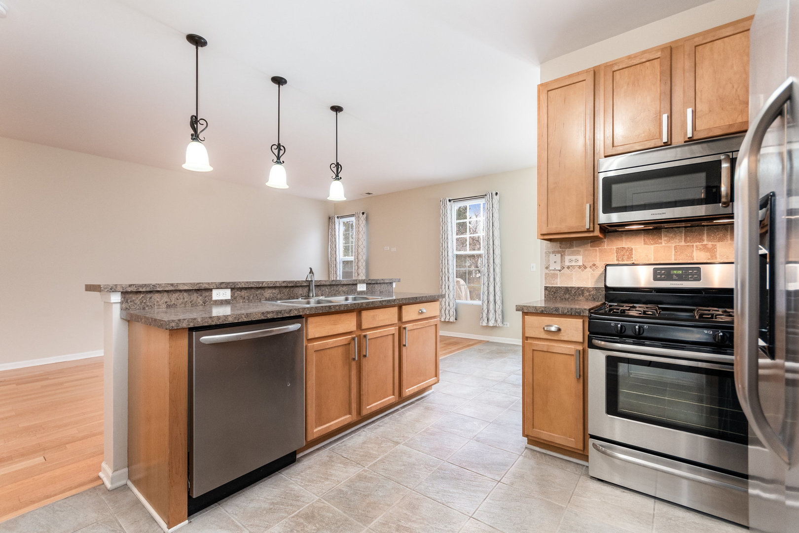 608 Springbrook Trail North Oswego, IL 60543 - Photo 9 of 24 a kitchen with stainless steel appliances granite countertop a stove and a microwave