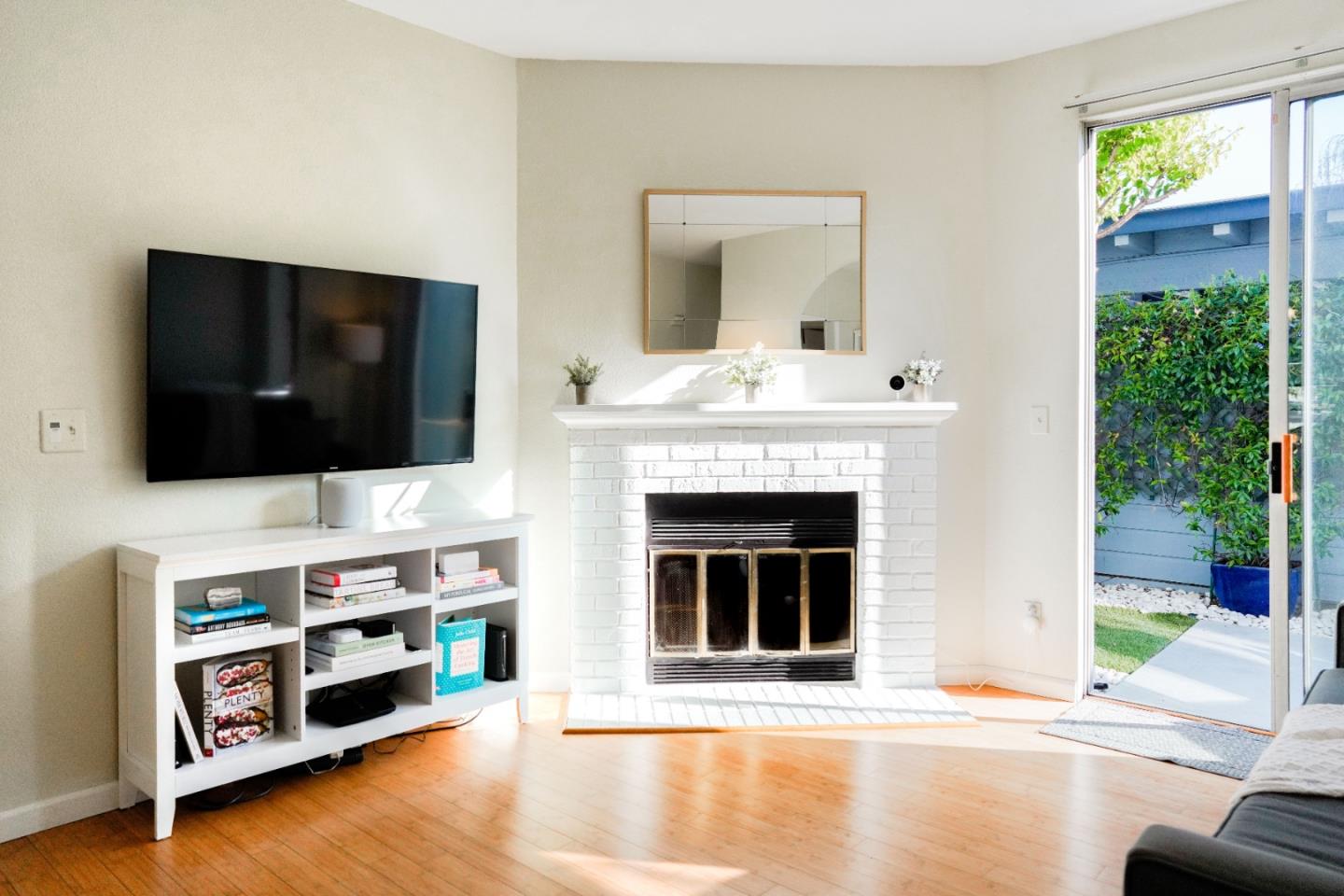 413 Cork Harbour Circle, Unit E Redwood City, CA 94065 - Photo 6 of 23 a living room with fireplace and flat screen tv