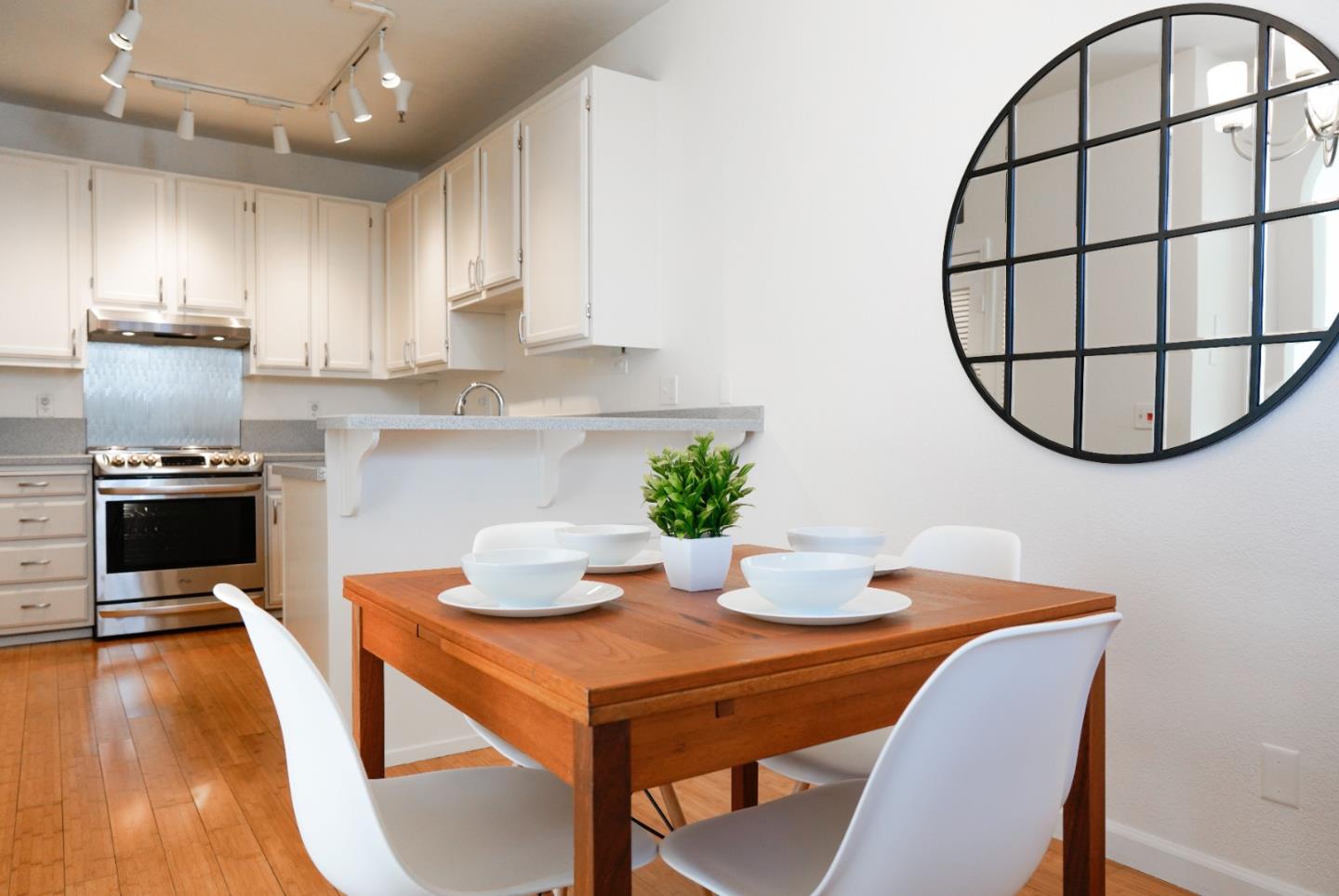 413 Cork Harbour Circle, Unit E Redwood City, CA 94065 - Photo 8 of 23 a kitchen with stainless steel appliances kitchen island granite countertop a dining table chairs and granite counter tops