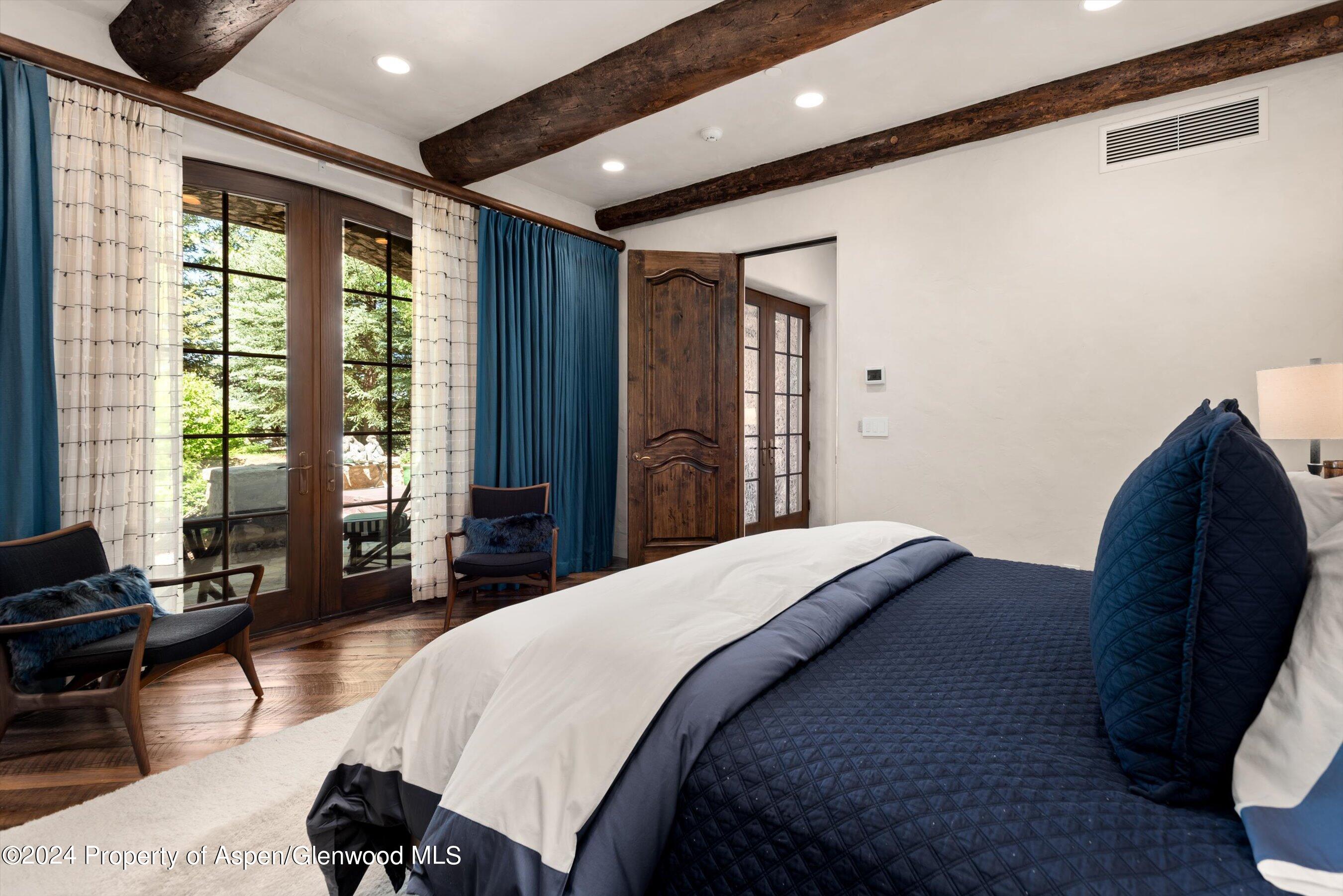 120 Running Mare Road Woody Creek, CO 81656 - Photo 39 of 53 a spacious bedroom with a bed and wooden floor