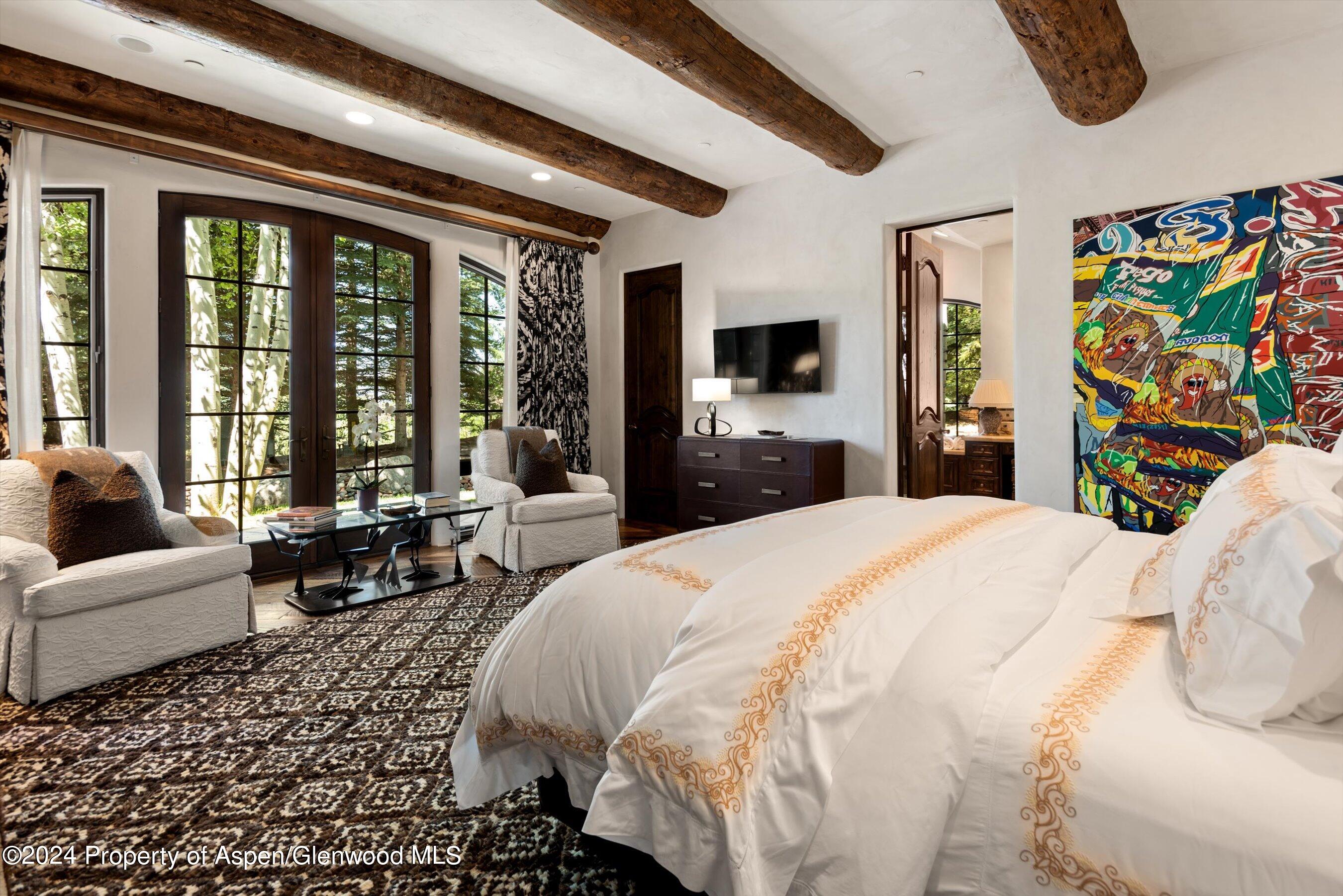 120 Running Mare Road Woody Creek, CO 81656 - Photo 40 of 53 a bedroom with a bed a couch and a flat tv screen on dresser