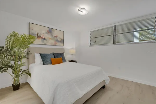 a bedroom with a bed and potted plant