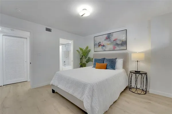 a bedroom with a large bed and a lamp on table
