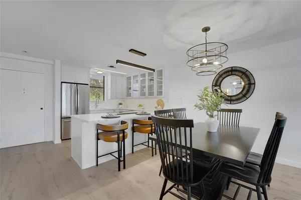 a view of a dining room with furniture a chandelier and wooden floor