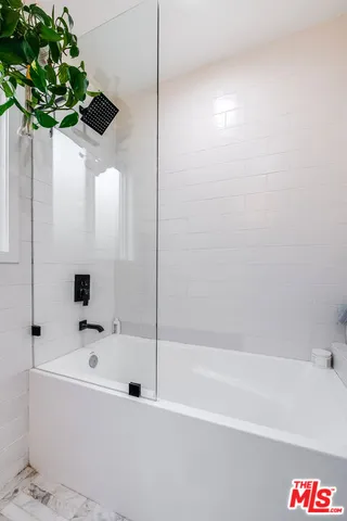 a bathroom with a bathtub and shower