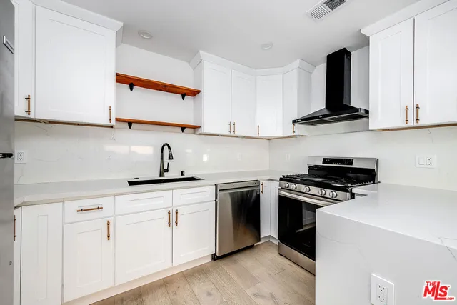 a kitchen with white cabinets and appliances
