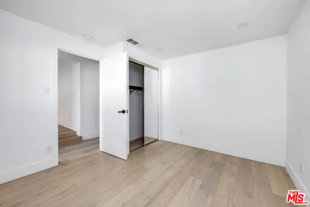an empty room with wooden floor and white doors