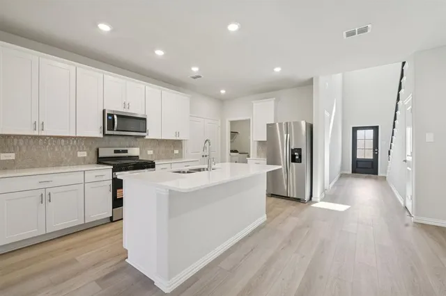 a kitchen with refrigerator cabinets and wooden floor