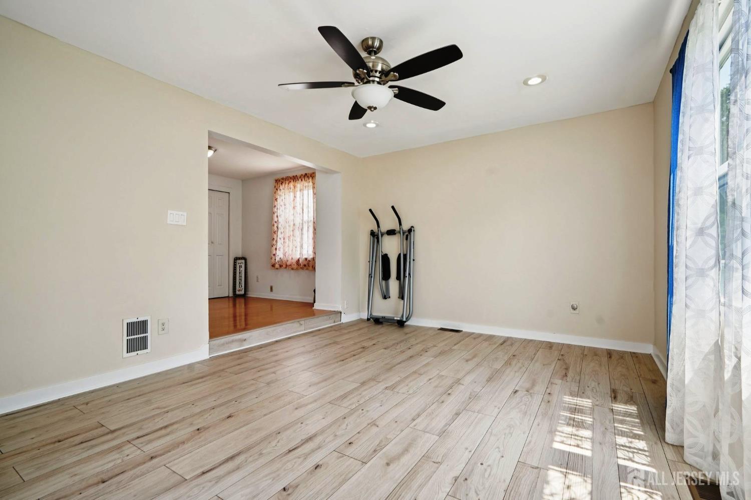 27 George Street Avenel, NJ 07001 - Photo 13 of 29 an empty room with wooden floor and a ceiling fan