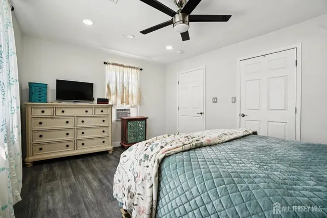 a bedroom with a bed and a flat tv screen on dresser
