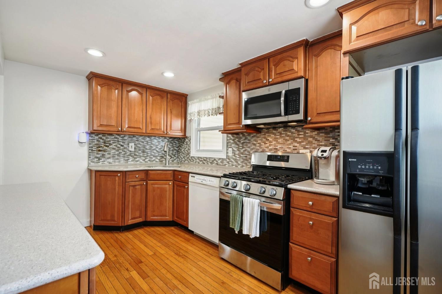 27 George Street Avenel, NJ 07001 - Photo 10 of 29 a kitchen with stainless steel appliances granite countertop a stove top oven a sink and a refrigerator