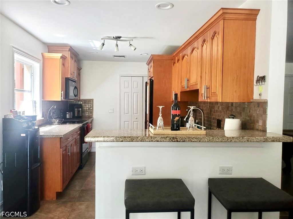 740 19th Street Southwest Naples, FL 34117 - Photo 24 of 35 a kitchen with stainless steel appliances granite countertop a sink and a refrigerator