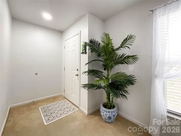 a glass vase with white table and a potted plant