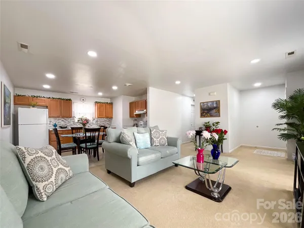 a living room with furniture and kitchen view