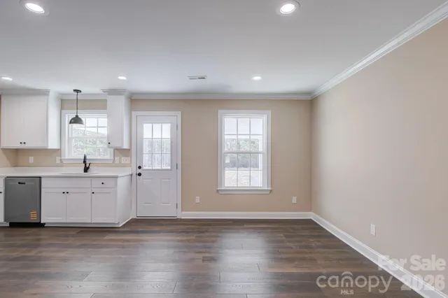 a view of an empty room with a chandelier fan