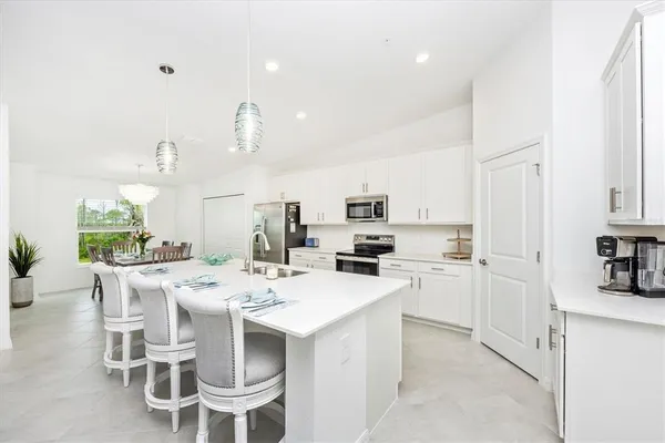 a kitchen with white cabinets and white appliances