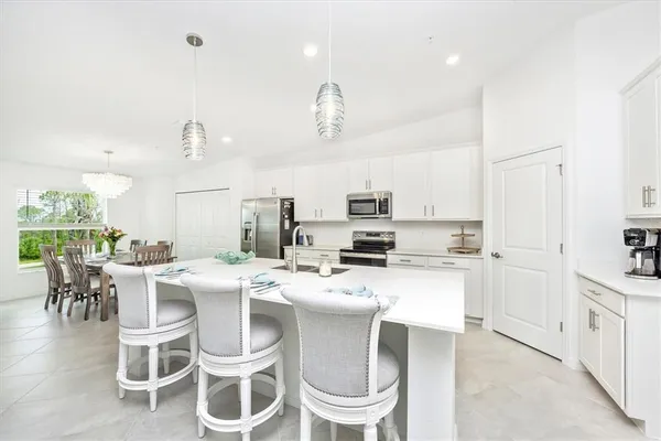 a kitchen with a refrigerator a stove a sink and chairs