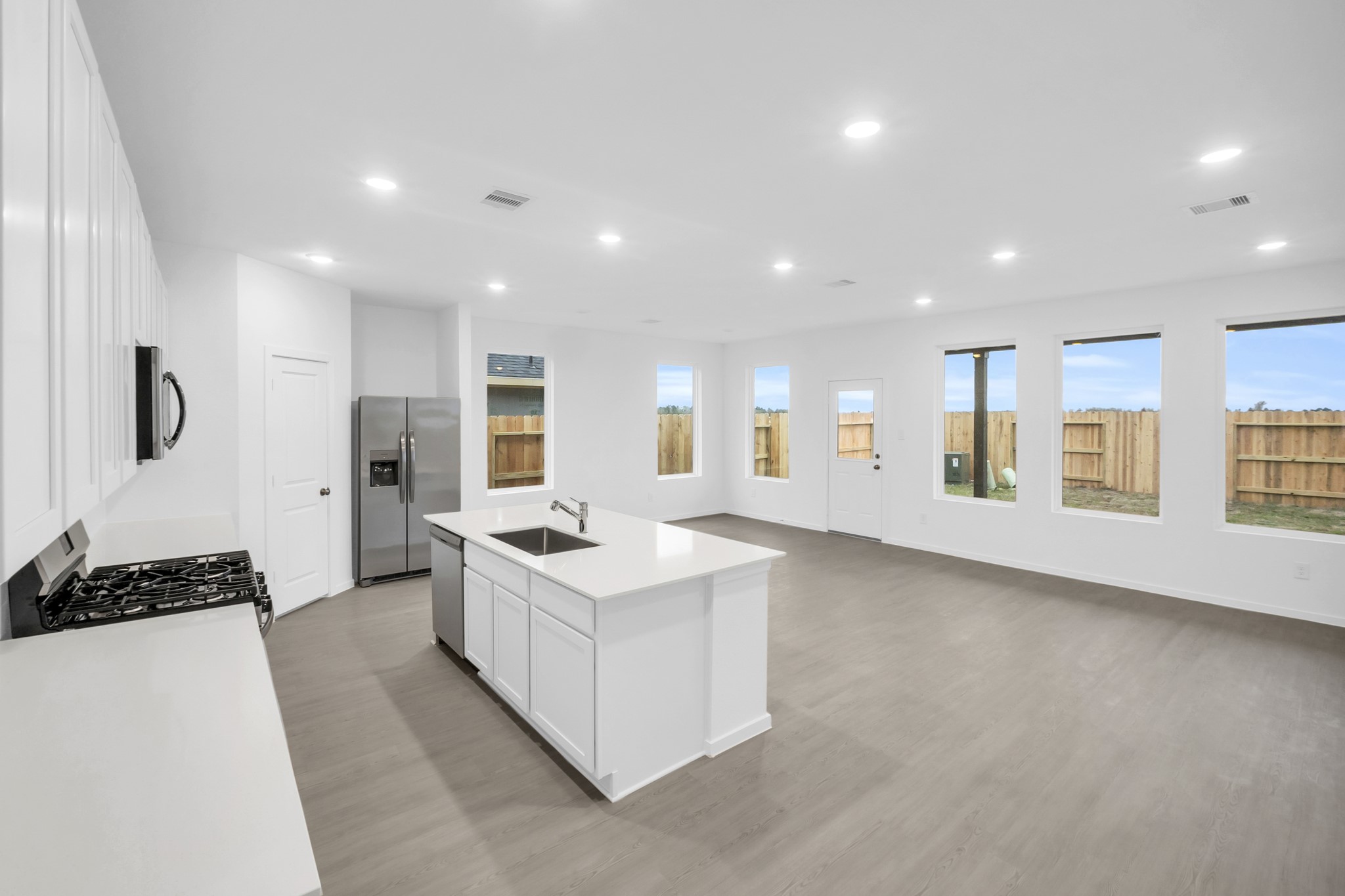2502 Jasper Breeze Drive Rosharon, TX 77583 - Photo 1 of 21 a large white kitchen with a sink and dishwasher a stove top oven with wooden floor