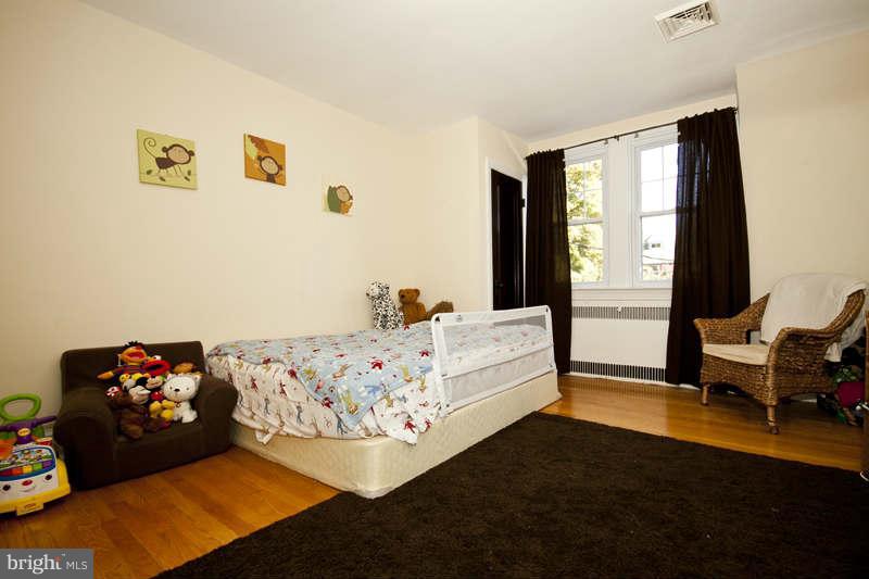 416 Hopkins Road Baltimore, MD 21212 - Photo 16 of 30 a bedroom with a bed and wooden floor