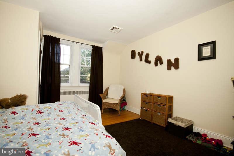 416 Hopkins Road Baltimore, MD 21212 - Photo 17 of 30 a bedroom with a bed and wooden floor